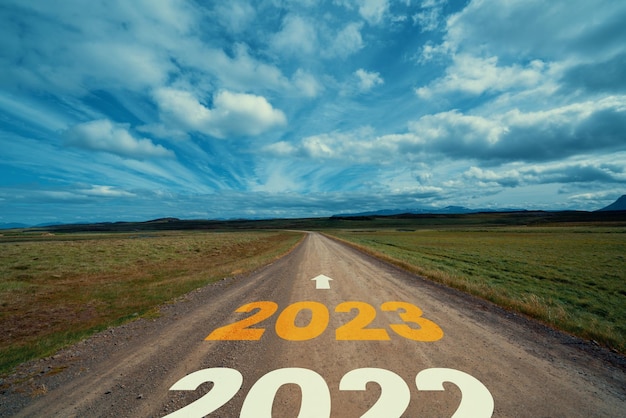 Новогоднее дорожное путешествие 2023 года и концепция видения будущего Природный ландшафт с шоссейной дорогой, ведущей к счастливому празднованию нового года в начале 2023 года для нового и успешного начала