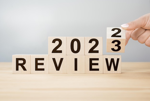 2023 nieuw jaar herzien Bedrijfsconcept van planning 2023 Zakenmanhand draait houten kubus om en verandert inscriptie Review 2022 om de resolutie van het nieuwe jaar van 2023 te herzien