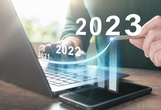 2023 nieuwjaar Zakelijk succes en investeringsgroei in 2023 jaar man hand met behulp van laptopcomputer met virtuele groeigrafiek grafiek diagram aandelenmarkt investeringen digitale technologie handel
