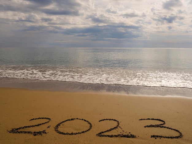 2023 numbers handwritten on the sand