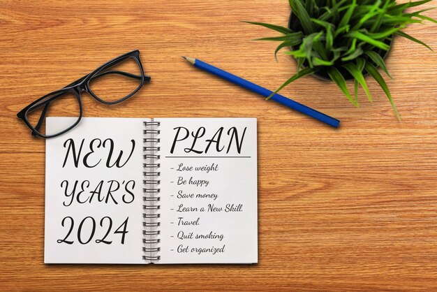 Photo 2024 happy new year resolution goal list and plans setting business office desk with notebook written about plan listing of new year goals and resolutions setting change and bliss concept