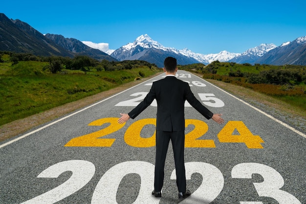 2024 new year journey and future vision concept businessman traveling on highway road leading forward to happy new year celebration in beginning of 2024 for bliss and successful start