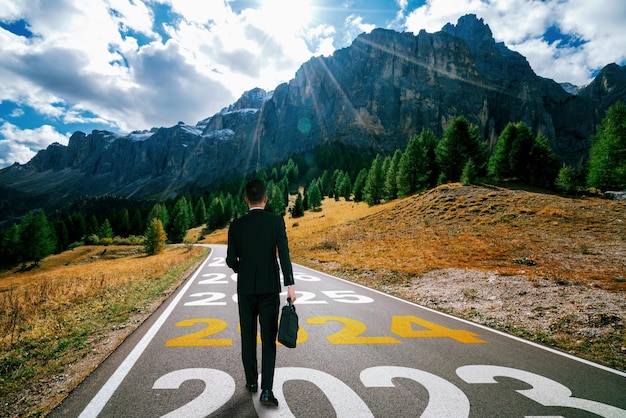 Foto il viaggio del nuovo anno 2024 e il concetto di visione del futuro l'uomo d'affari che viaggia sulla strada autostradale che porta avanti alla felice celebrazione del nuovo anno all'inizio del 2024 per la felicità e un inizio di successo