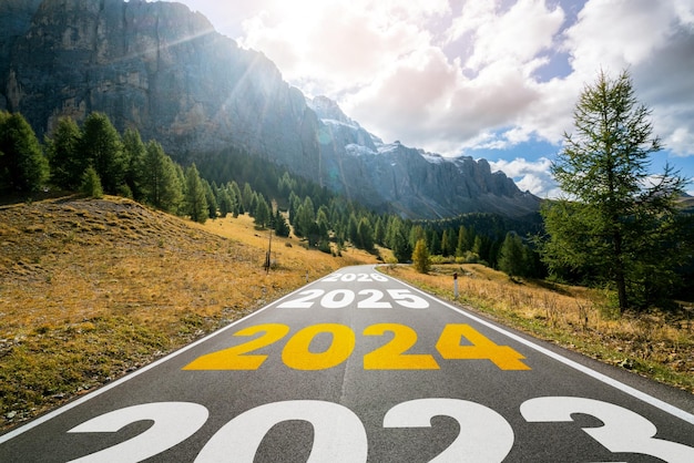 Foto 2024 nieuwjaarsreis op de weg reis en toekomstvisie concept natuurlandschap met snelweg weg die leidt naar een gelukkige nieuwjaarsviering in het begin van 2024 voor geluk en een succesvolle start