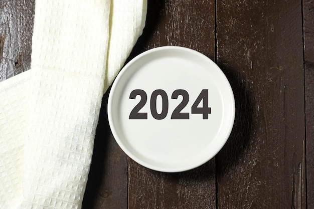 2024 number written on a white plate on wooden table with napkin