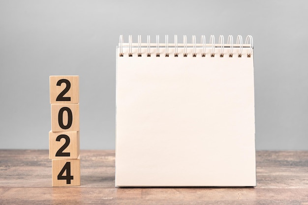 2024 tijd voor een nieuwe start Plan woorden en 2024 kubussen houten tafel achtergrond Nieuwjaarsplannen voor 2022 lege ruimte voor tekst op notitieboek mockup kalender