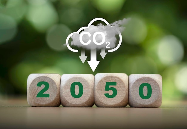 2050년, 기후 변화로 인한 지구 온난화를 제한하기 위해 CO2 배출 탄소 배출량 및 탄소 크레딧을 줄이기 위해 녹지 배경에 CO2 감소 아이콘 교토 의정서 개념