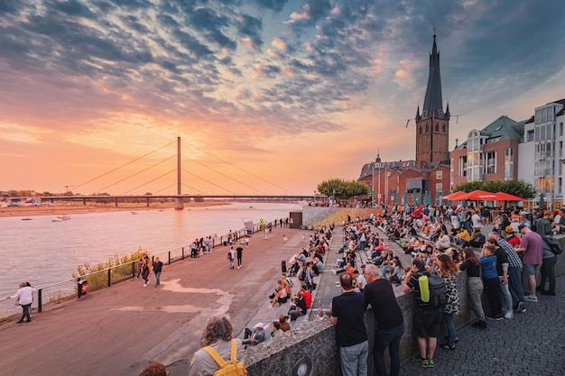 22 июля 2022 г. Дюссельдорф Германия Люди отдыхают и наслаждаются выступлением уличных музыкантов и закатом над рекой Рейн недалеко от старого города в Рейнтреппе