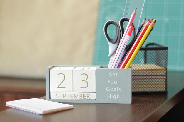 23 settembre immagine del calendario in legno del 23 settembre sul desktop ritorno a scuola matite