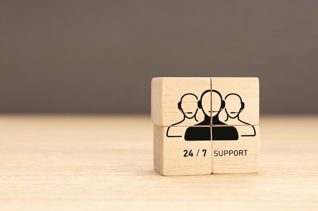 247 Customer support concept Group of wooden block with Group of Call Center Workers icon Copy space