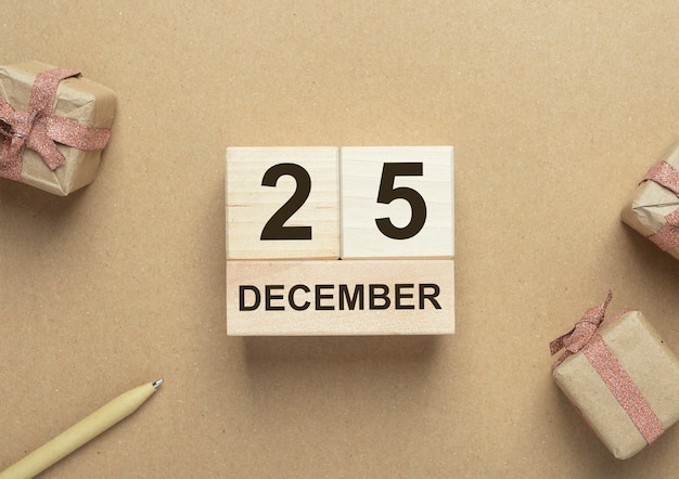 25 december datum op houten kalender over ambachtelijke eco achtergrondkleur. Eco kerst concept.