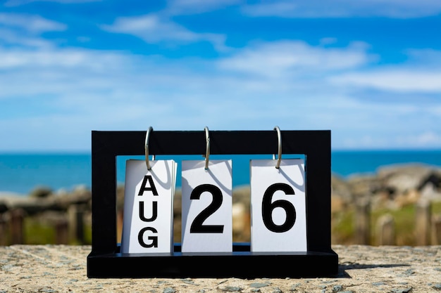 Foto 26 aug kalender datum tekst op houten frame met wazige achtergrond van de oceaan kalender datum concept