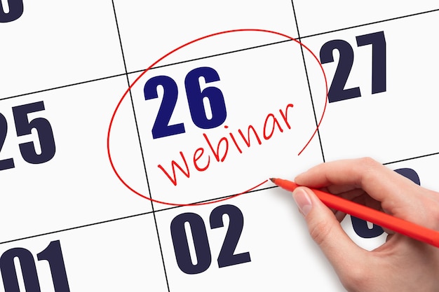 26th day of the month Hand writing text WEBINAR and circling the calendar date