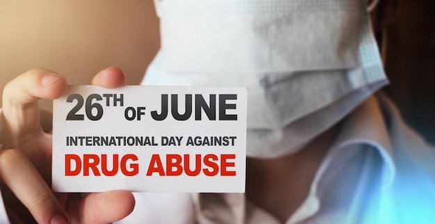 26th of June International Day Against Drug Abuse on white card in Doctor hand Drugs addiction awarenes medical healthcare concept