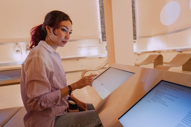 28 July 2022 Essen Germany girl uses a touchscreen terminal to get information about exhibition in jewish museum in Essen Synagogue