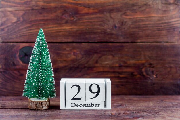 29 december op de calendar.Calendar met een kleine kerstboom op een houten achtergrond. Winter. Lege ruimte voor tekst.