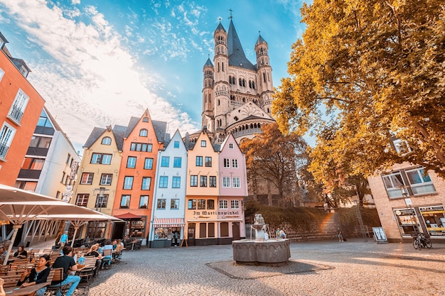 29 july 2022 cologne germany fish market square with tourists resting in cafes colorful houses and st martin church in koln travel and sightseeing