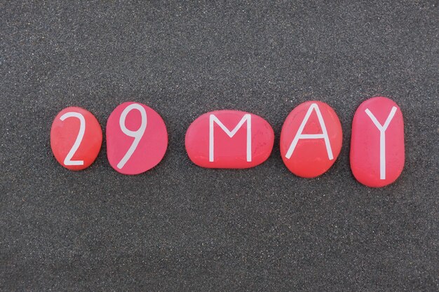 Photo 29 may calendar date composed with red colored stone letters over black volcanic sand