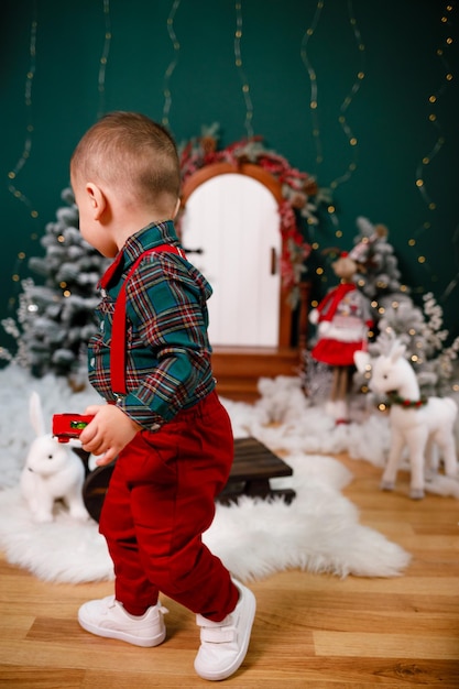 A 2yearold boy runs at home with toys in his hands Children's pants and shirt