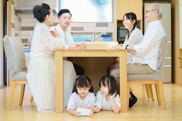 3 generaties familiebijeenkomst aan tafel in de kamer