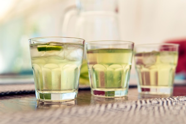 3 glasses of cool refreshing lemonade are on a wooden table in a summer cafe. Homemade lemonade