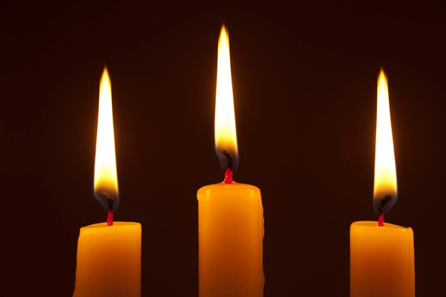 Фото 3 зажженные свечи на темном фоне горизонтальный снимок