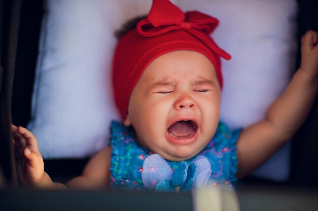 3 month old baby in wheelchair on the street is crying