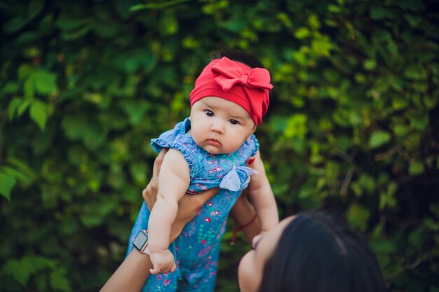 屋外のママの手で3ヶ月歳の子供。新生児のための最初の散歩