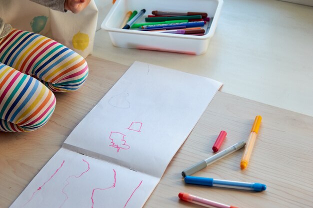 写真 3歳の女の子が絵を描きます。 covid-19の期間中、在宅の子供、幼稚園、幼稚園は閉鎖されました