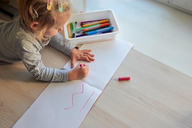 3 years girl draws a picture. Child at home, kindergarden and preschool closed during Covid-19