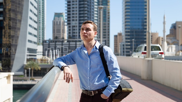 A 35 40 year old man stands in the center of a big city and looks around with interest