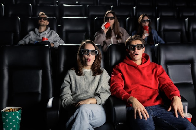 Photo 3d cinema a young couple is surprised to watch a fantasy movie with 3d glasses