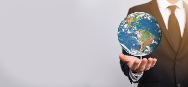 Глобус планеты земли 3D в руке человека, женщине, руках на голубой предпосылке. Концепция защиты окружающей среды. Элементы этого изображения предоставлены НАСА