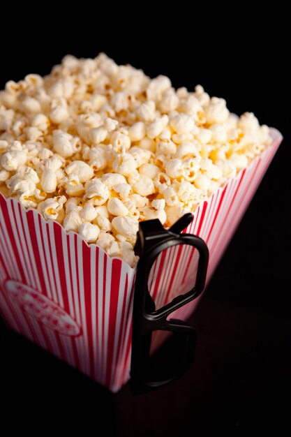 3D glasses hanging on the corner of a box of popcorn