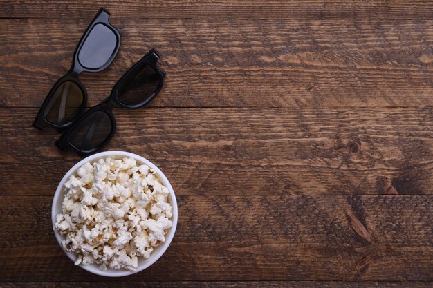 Occhiali 3d e popcorn sul tavolo. vista dall'alto