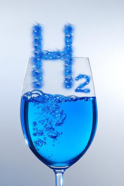 3D illustration pure energy blue h2 hydrogen with bubbels over a glass and blue liquid