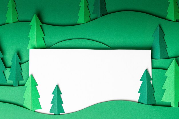 Foto 3d pop-out alberi di natale di carta materiale illustrativo nel muro verde. scheda di disegno di taglio della carta dell'albero di natale. vista dall'alto. lay piatto