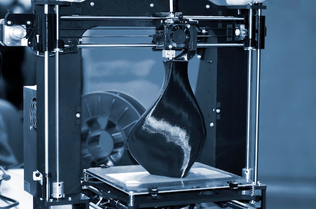 3D-printer die een model afdrukt in de vorm van een zwarte vaasclose-up Het concept moderne additieve technologie De 4ht industriële revolutie Blauwgrijze kleur