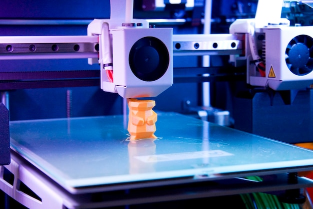 A 3d printer is shown with a blue background.