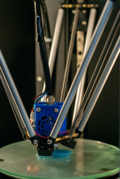 3D printer printhead during printing volume detail in close-up with blurred background