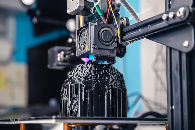 Photo a 3d printer prints a black model technology at home