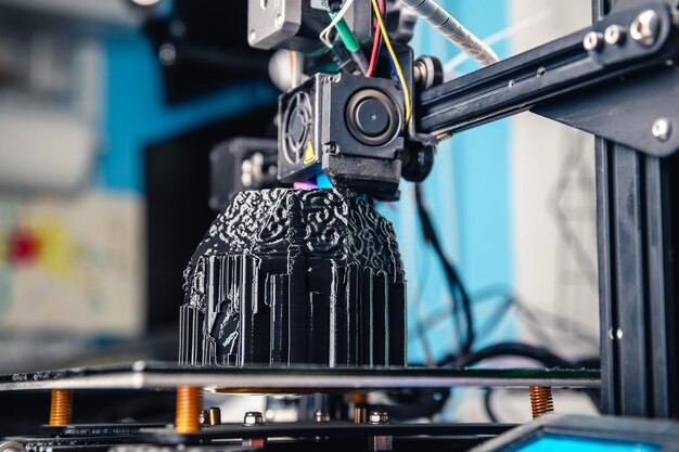 Photo a 3d printer prints a black model technology at home