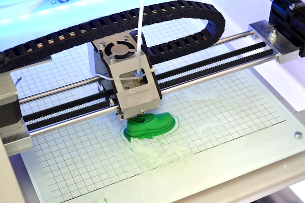 3D printer prints the form of molten plastic green