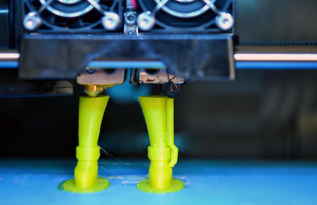 Photo 3d printer prints the form of molten plastic green