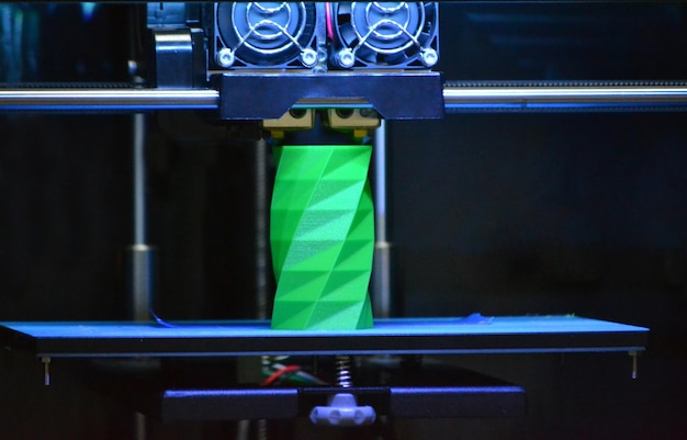 3D printer works and creates an object from the hot molten plastic