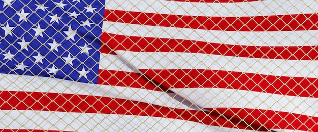 3D render van de Amerikaanse vlag achter een stalen gaasdraadomheining de vlag van Amerika