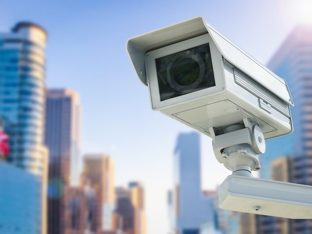 3D-rendering cctv-camera of beveiligingscamera op stadsgezicht achtergrond