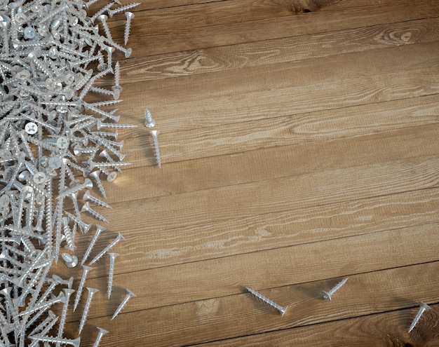 3D rendering of lots of screws and a wooden background