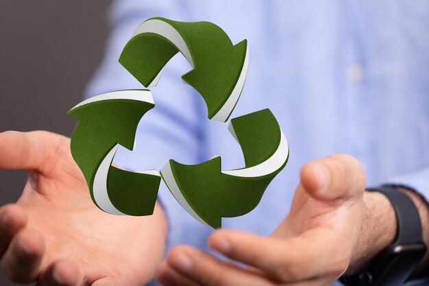 3d rendering of the recycle sign with a mans hands below