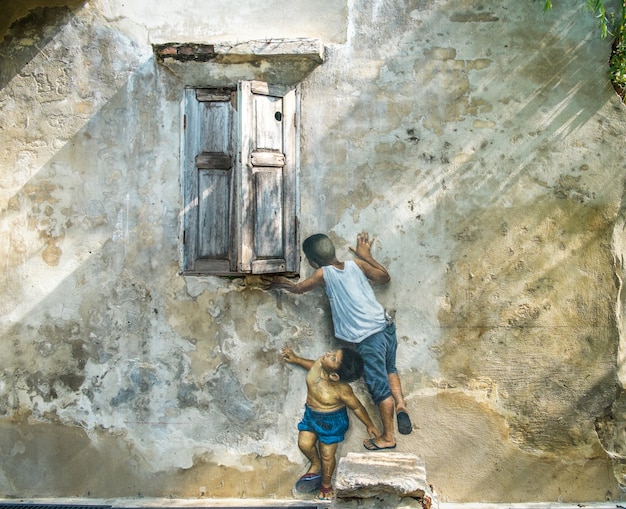 3D-straatkunst op de muur. Schilderij van jongens speelt bij het raam.
